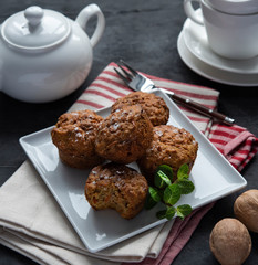 Fototapeta na wymiar Some carrot muffins with nuts and mint white cup of tea breakfast bakery
