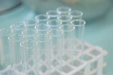 Empty test tube small beakers in a stand on a turquoise table cloth
