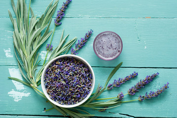 a pile of fresh lavender flowers and syrup on blue wooden table background