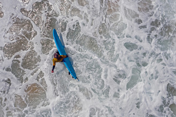 Aerial from a surfer going to surf in the atlantic ocean