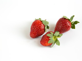 Ripe strawberry on white background. Three berries.