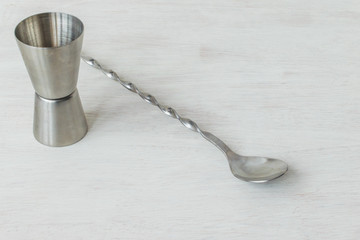 Jigger and mixing spoon on a white background with space for text