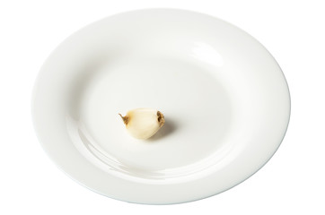 A white plate with a slice of garlic isolated on white