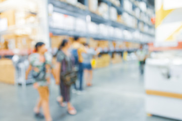 Blurred bix box store supercenter with customers shopping for home goods.