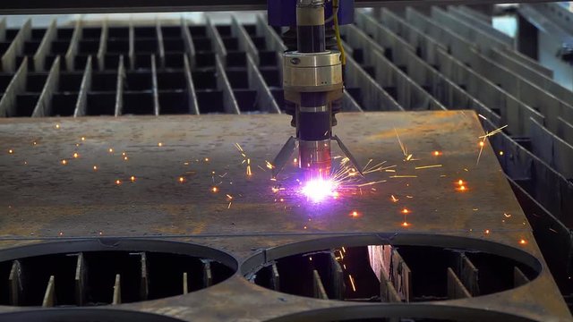 plasma cutter cuts metal sheet, Cut sheet metal at workshop, Modern tool in heavy industry, Plasma laser cutting metal sheet with sparks, automatic CNC plasma cutting machine working with an aluminum 