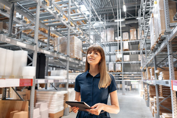 Wholesale warehouse. Beautiful young woman worker of store in shopping center. Girl looking for...