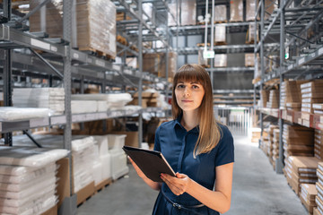 Wholesale warehouse. Beautiful young woman worker of store in shopping center. Girl looking for...