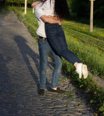 Fototapeta premium Happy couple in love hugging and kissing while walking in the park