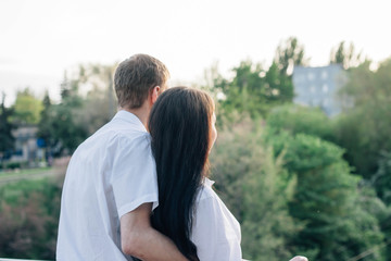 Happy couple in love hugging and kissing while walking in the park