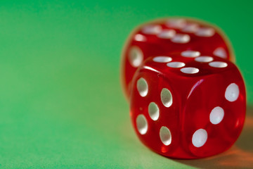 Closeup of a two red dice with a winning number on the top face on a green surface