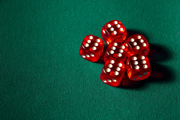 Close-up of several red dice with different digital combinations on green cloth in a casino