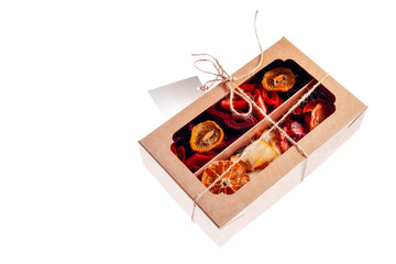 Box with marshmallow and dried fruit on a white background