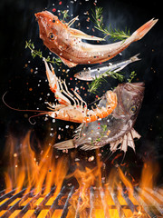 Kettle grill with fire flames, cast iron grate and tasty sea fishes flying in the air. Freeze motion barbecue concept.