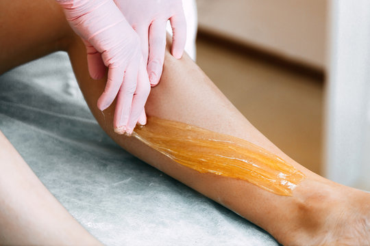 Sugaring Sugar waxing feet in the beauty salon.