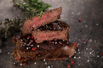 Grilled beef steak on black stone table, close-up