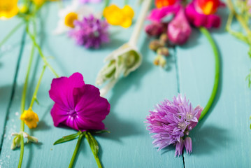 herbal and wildflowers on blue wooden table background