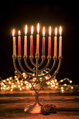 Concept of jewish holiday Hanukkah with menorah (traditional candelabra) and burning candles.