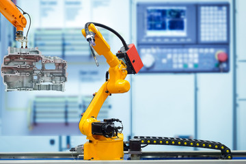 Moving welding robot and robot gripping working with engine parts of motorbike on blurred smart...