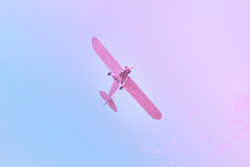 Small plane flying against the blue, purple, pink sky
