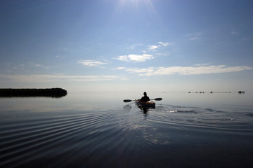 Kayaker enjoying a very calm early morning paddle on Biscayne Bay in Biscayne National Park, Florida