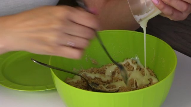 A woman mixes a cookie crumb with condensed milk. Cooking basics for cake pops