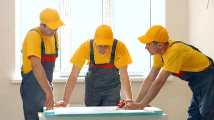 Builders working with documents on construction site. Building and home renovation.
