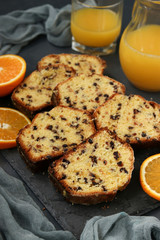 Cupcake with oranges and chocolate, located on a slate stand against a dark background