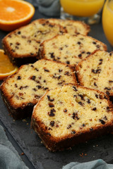 Cupcake with oranges and chocolate, located on a slate stand against a dark background