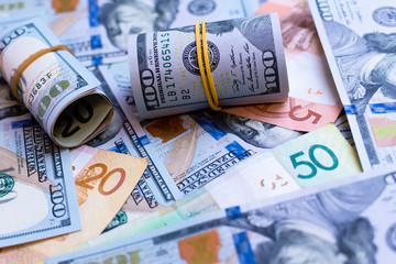 National currencies of various countries in one big pile of money close up. American dollars and banknotes of European states сash money