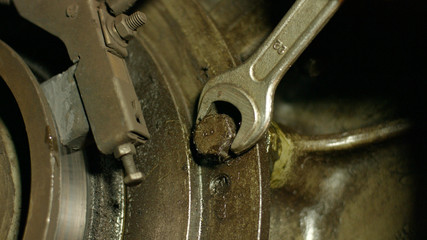 Engine repair close up. Mechanic tightening the screws. Repair of equipment. Mechanic repairing a car.