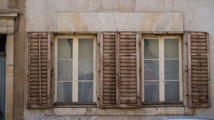 Fototapeta na wymiar 2 windows with old, beige shutter in Nanc, France- european style 
