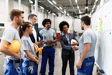 Obraz na płótnie Canvas African American businesswoman handshaking with a worker while visiting factory.