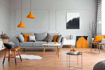 Orange accents in a grey living room interior