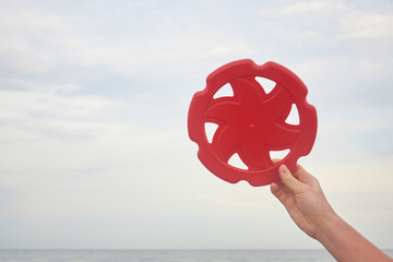Frisbee in woman hands on the beach