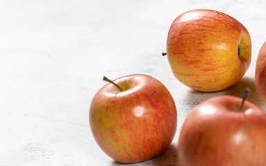 Bright red and yellow apples - fuji kiku variety - on white board, sapce for text left