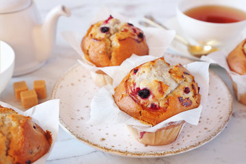 Three blueberry muffins and cup of tea