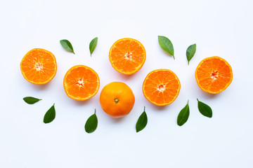 Fresh orange citrus fruit with green leaves on white.