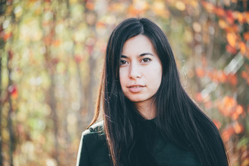 Female beauty portrait surrounded by vivid foliage. Dreamy beautiful girl with long natural black...