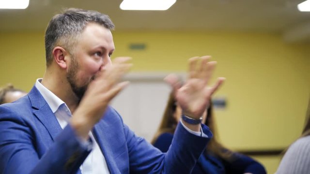 Executive leader explaining the main rules of successful business gesticulating a lot. Businessman shares his experience with the audience in a conference hall.
