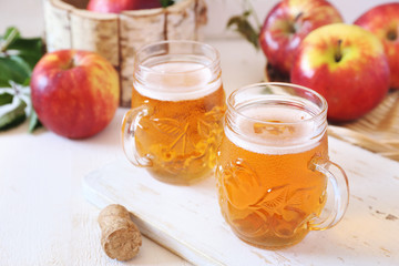 Two cups of Apple Cider and red apples