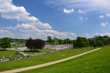 People looking for refreshment in the Multimedia Fountain park in Warsaw during a hot summer day