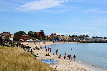 Hel, Hel Peninsula, Poland. People relaxing at the beach in Hel. Late summer day at sandy beach in Hel town. - obrazy, fototapety, plakaty