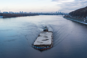 The barge floating in the Dnieper river. Kyiv city landscape in the background. 17.11.2018