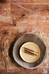 High angle view of craft knives and cutters on stacking ceramic plates place on scratched table...