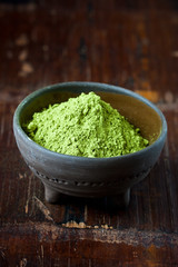 Powdered matcha green tea on wooden table