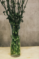 The stems of flowers in a bouquet in a vase