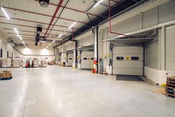 Distribution warehouse logistics center. Warehouse and shipping facility. Industrial factory interior with truck terminal.