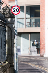 Twenty mile per hour speed limit sign reminder on a lampost in a city centre street.