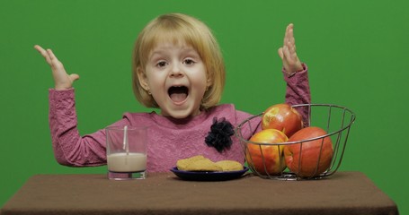 Girl sitting at the table with cacao, apples and cookies. Chroma Key