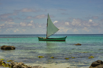 Fototapeta premium photo of a sailing boat in the sea with blue sky and white clouds